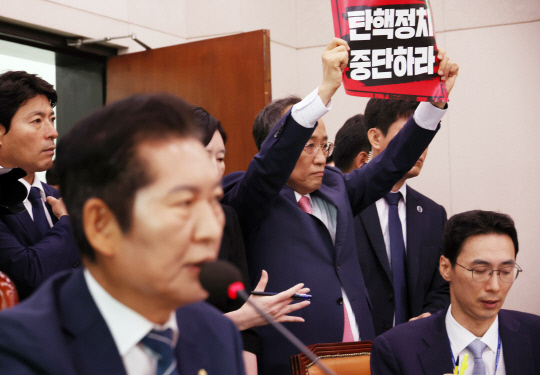 더불어민주당 소속 정청래 국회 법제사법위원회 위원장이 지난 19일 오전 국회 법사위에서 열린 '윤석열 대통령 탄핵소추안 발의 요청' 국민동의 청원 청문회에서 추경호 국민의힘 원내대표가 항의 피켓을 들고 서 있는 가운데 발언하고 있다. [연합뉴스 제공]